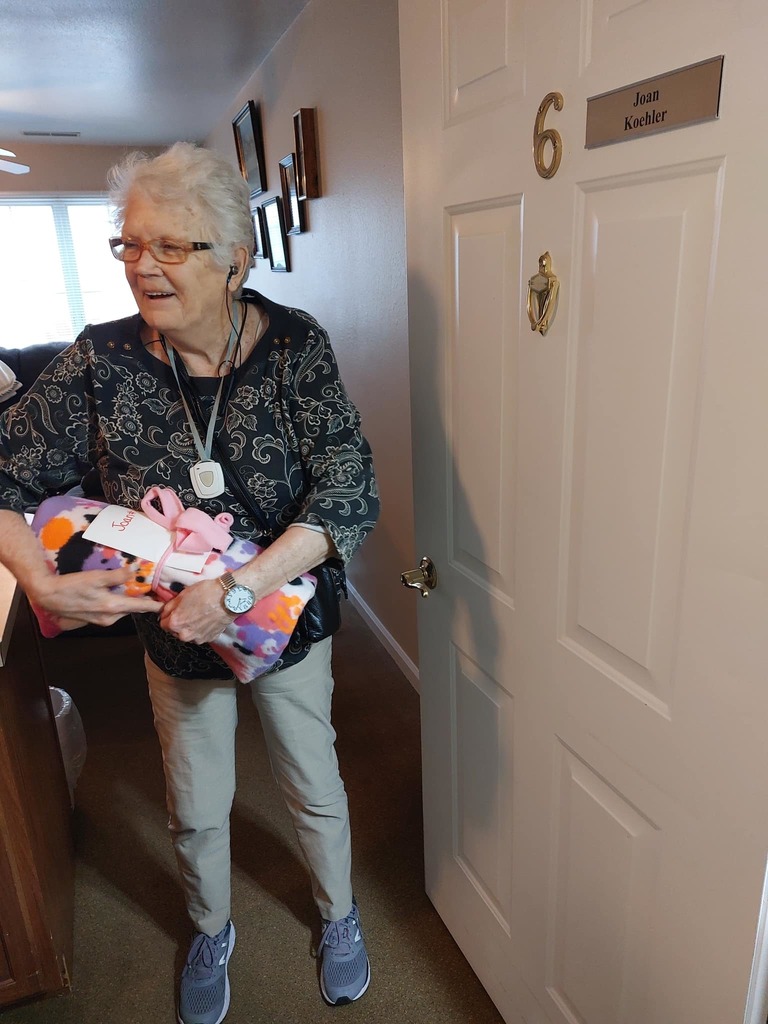 senior adult in her apartment receiving gift 