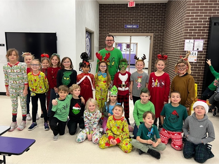 Mr. Johnson, principal, poses with 2nd grade students for Grinch Day photo