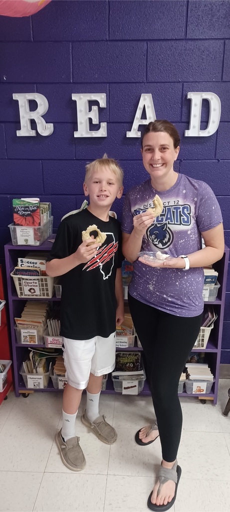 Carson sharing the bagel with his reading teacher.